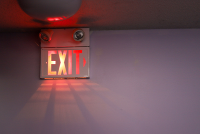 Exit Signage An exit sign lit up in a dark hallway